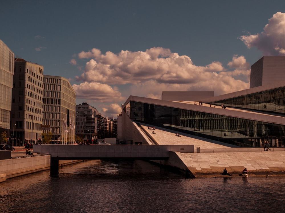 Biały, pochyły dach opery w Oslo nad wodą fiordu